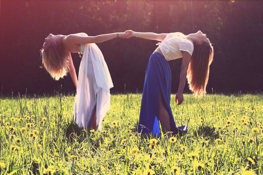 "two women bending while holding hands" photo credit Julia Caesar, unsplash