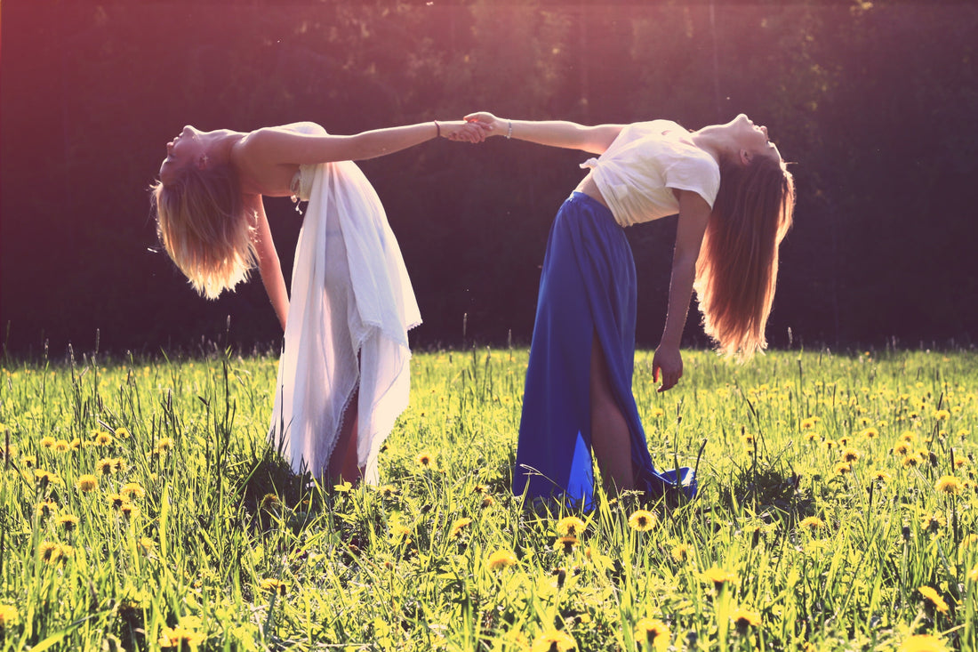 "two women bending while holding hands" photo credit Julia Caesar, unsplash